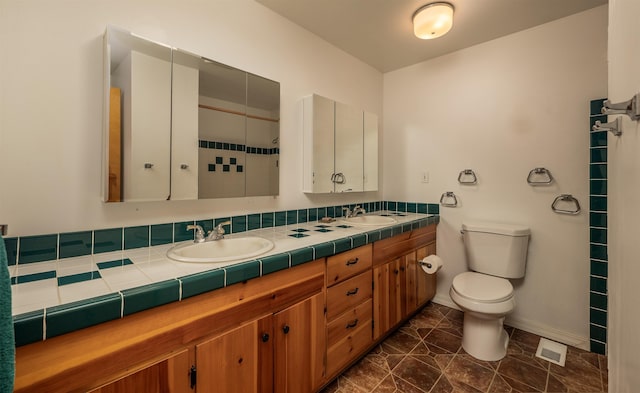 bathroom featuring visible vents, a sink, toilet, and baseboards