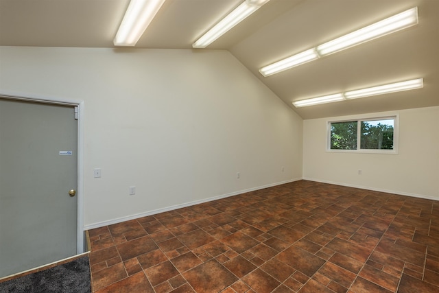 unfurnished room with lofted ceiling and baseboards