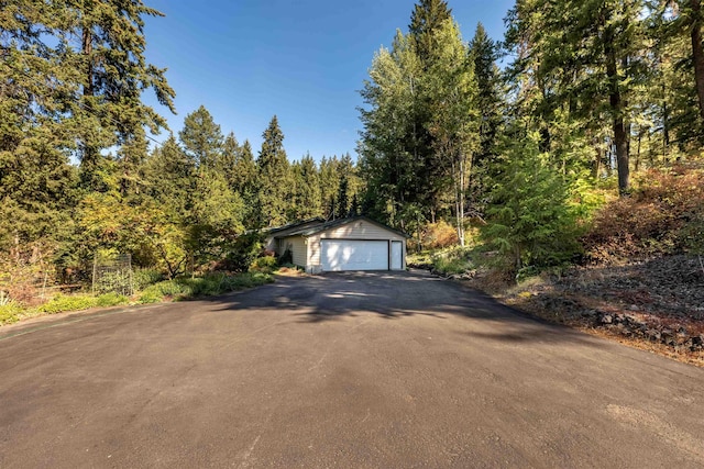 detached garage featuring a view of trees