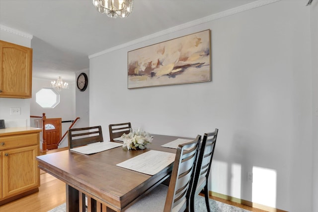 dining space featuring a chandelier, light wood-style floors, and ornamental molding