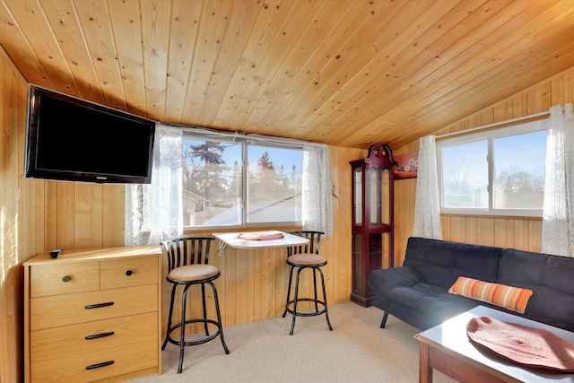 living area featuring vaulted ceiling, wooden ceiling, light colored carpet, and wood walls