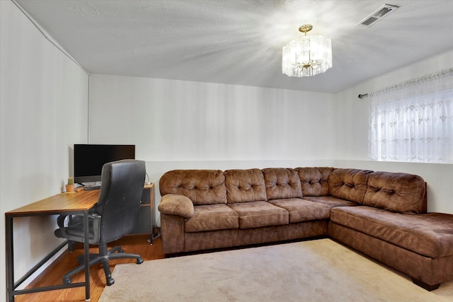 home office featuring wood finished floors, visible vents, and an inviting chandelier