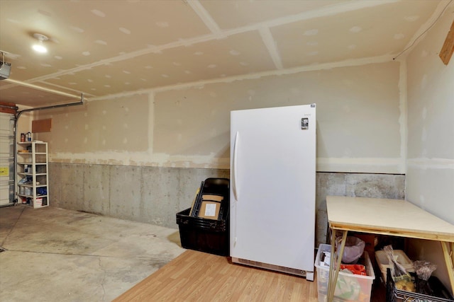 interior space with freestanding refrigerator and a garage door opener