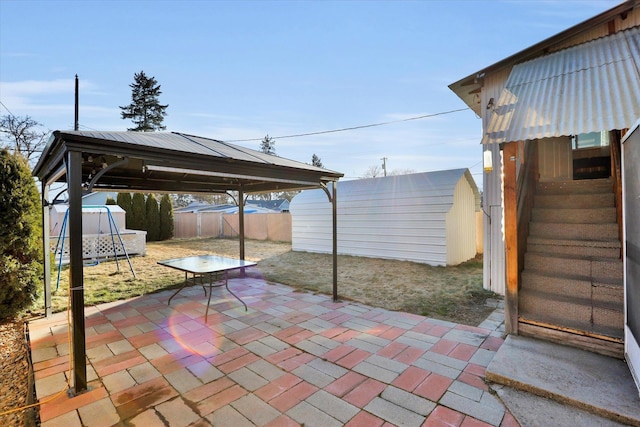 view of patio featuring a gazebo, a fenced backyard, a storage unit, and an outdoor structure