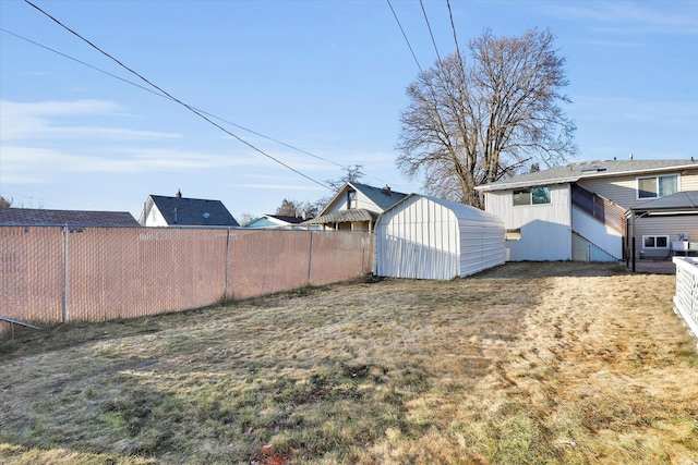 view of yard featuring an outbuilding, fence, and a storage unit