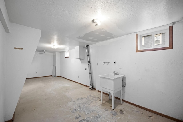 basement featuring a textured ceiling and baseboards