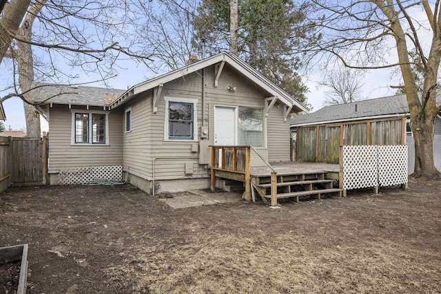 back of property featuring a chimney, a sunroom, fence, and a deck