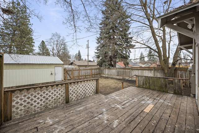 wooden deck featuring an outdoor structure and a fenced backyard