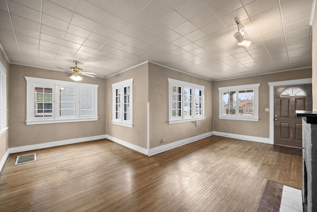 foyer with ornamental molding, visible vents, baseboards, and hardwood / wood-style flooring