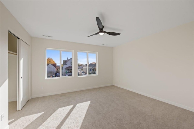 unfurnished bedroom featuring visible vents, light carpet, and baseboards