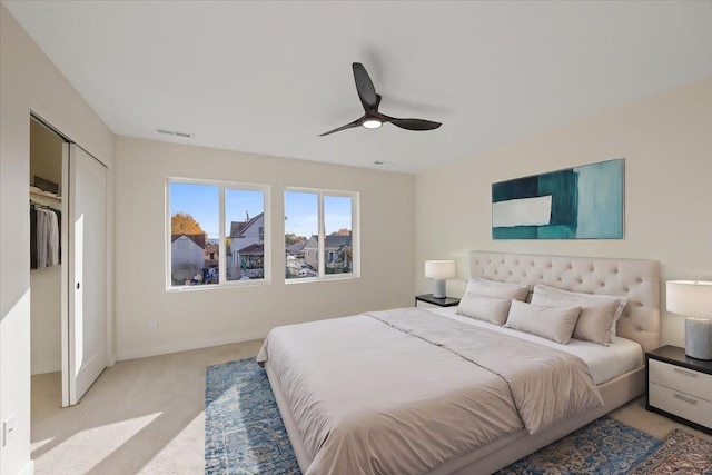 bedroom featuring baseboards, ceiling fan, visible vents, and light colored carpet