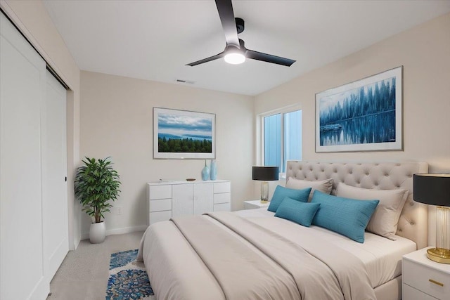 carpeted bedroom with ceiling fan, a closet, visible vents, and baseboards