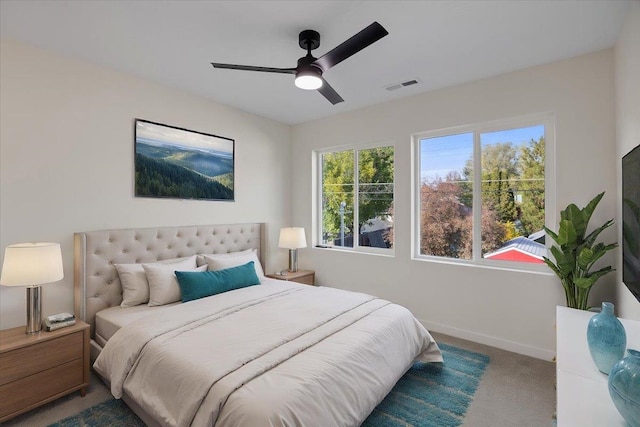 carpeted bedroom featuring a ceiling fan, visible vents, and baseboards