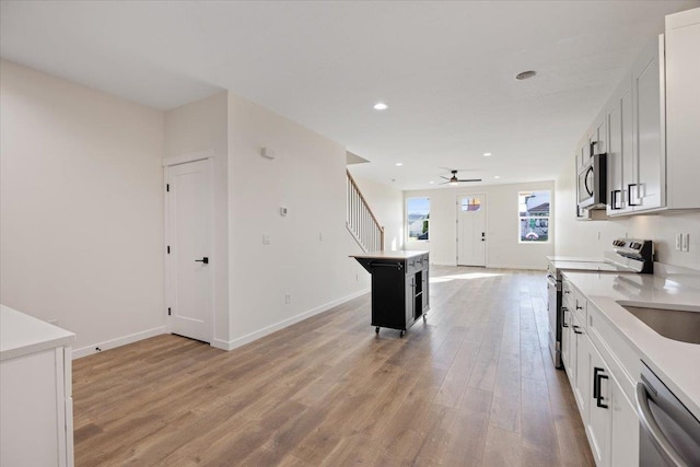 kitchen featuring recessed lighting, baseboards, light countertops, appliances with stainless steel finishes, and light wood finished floors