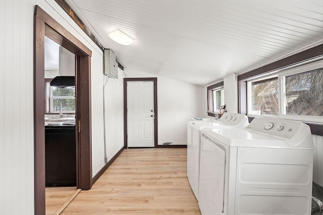 laundry room featuring laundry area, a sink, baseboards, light wood finished floors, and washing machine and clothes dryer