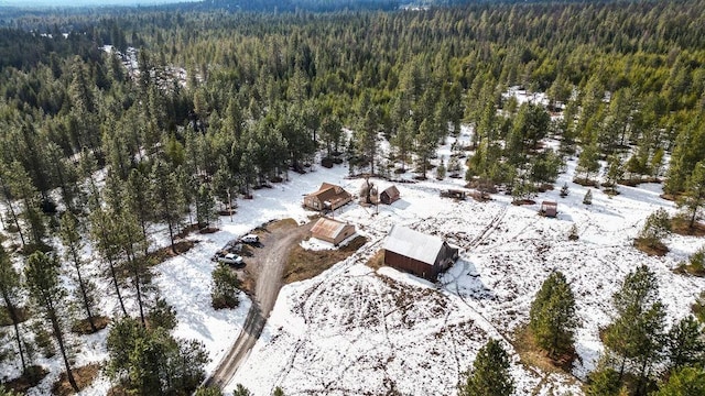 snowy aerial view with a wooded view