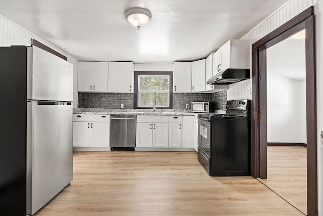 kitchen featuring under cabinet range hood, white cabinetry, appliances with stainless steel finishes, backsplash, and light wood finished floors