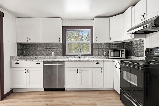 kitchen with stainless steel appliances, light wood-type flooring, a sink, and under cabinet range hood