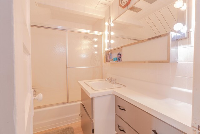 bathroom with enclosed tub / shower combo and vanity