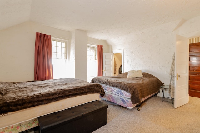 carpeted bedroom with lofted ceiling, a textured ceiling, and a textured wall