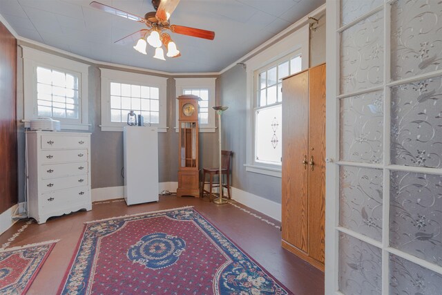 interior space featuring ornamental molding, ceiling fan, and baseboards