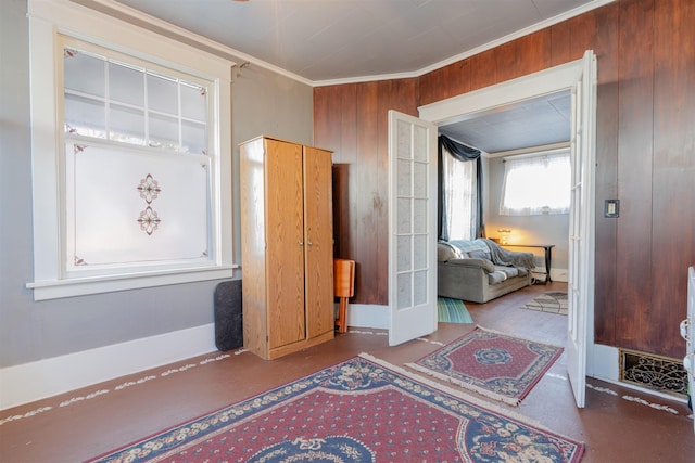 entryway featuring wooden walls, concrete flooring, and crown molding