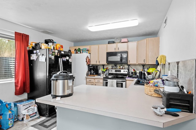 kitchen featuring black microwave, light countertops, a sink, and stainless steel electric stove