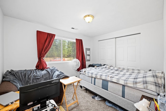 carpeted bedroom with a closet and visible vents