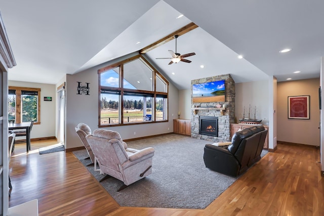 living area featuring lofted ceiling with beams, a fireplace, baseboards, and wood finished floors