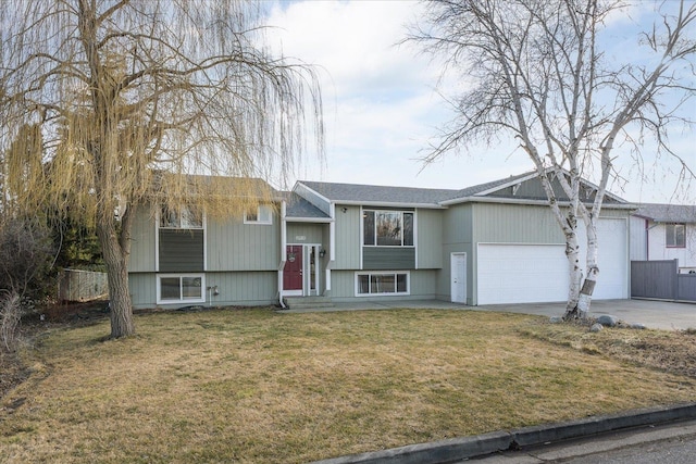 raised ranch with a garage, a front lawn, and concrete driveway