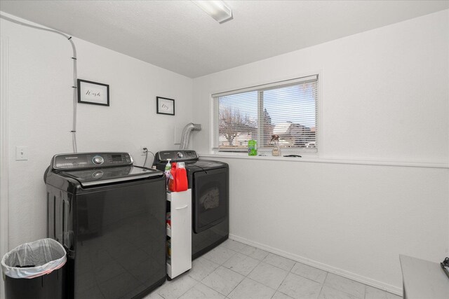 washroom with laundry area, independent washer and dryer, and baseboards