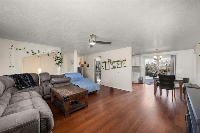 living room featuring dark wood finished floors, a textured ceiling, and ceiling fan with notable chandelier