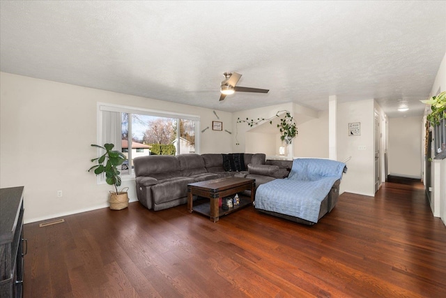 living room with a textured ceiling, ceiling fan, wood finished floors, and visible vents