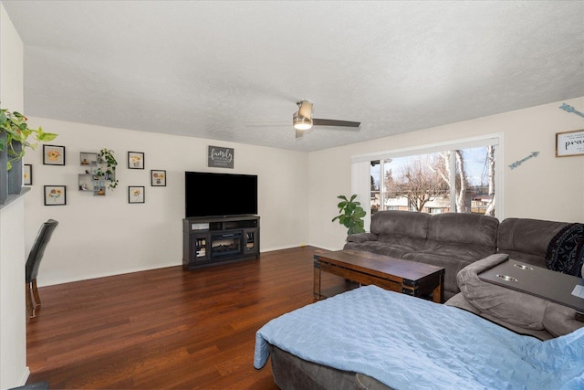 living area featuring a textured ceiling, ceiling fan, and wood finished floors