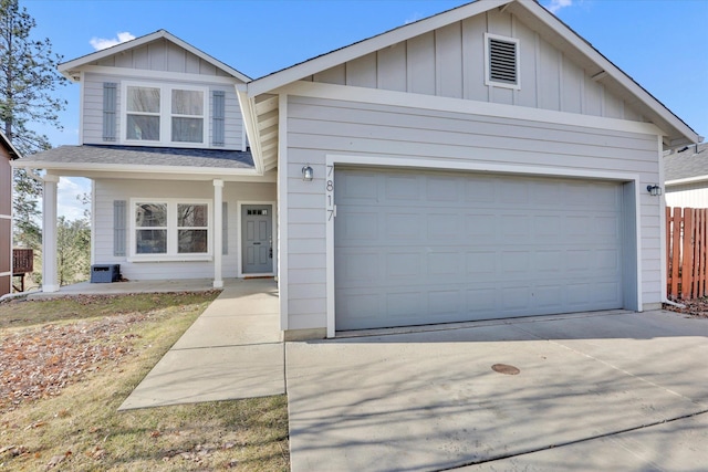 view of front of home featuring board and batten siding, concrete driveway, fence, and a garage