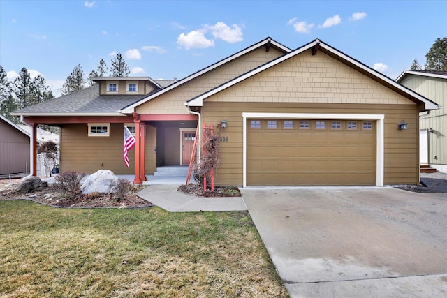 view of front of home with driveway, an attached garage, and a front yard