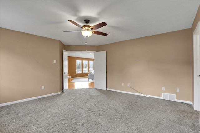 unfurnished room featuring a ceiling fan, baseboards, visible vents, and carpet flooring