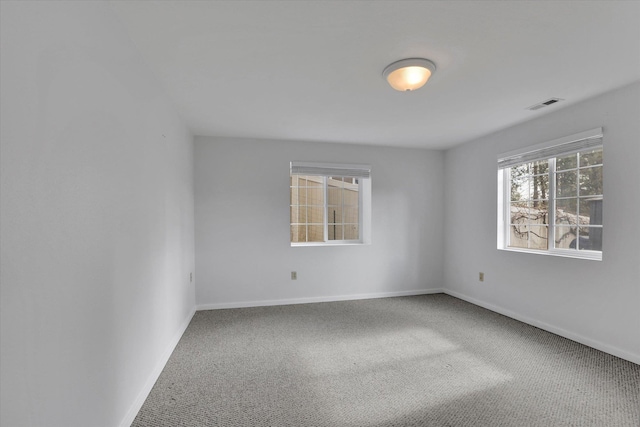 carpeted empty room featuring visible vents and baseboards