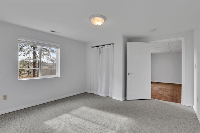 unfurnished bedroom featuring carpet floors, visible vents, and baseboards