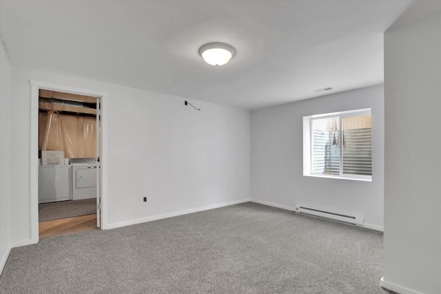 spare room featuring carpet, washing machine and dryer, baseboards, and baseboard heating