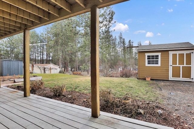 wooden deck with a storage unit, a lawn, and an outdoor structure