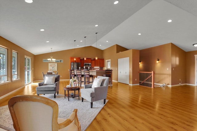 living room featuring light wood finished floors, baseboards, lofted ceiling, an inviting chandelier, and recessed lighting