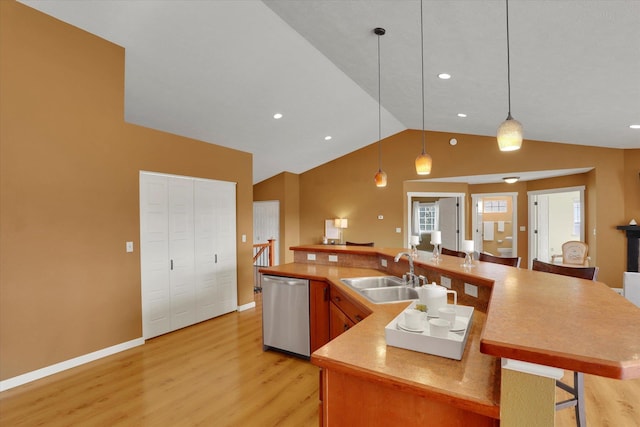 kitchen with a kitchen breakfast bar, a sink, vaulted ceiling, light wood-style floors, and stainless steel dishwasher