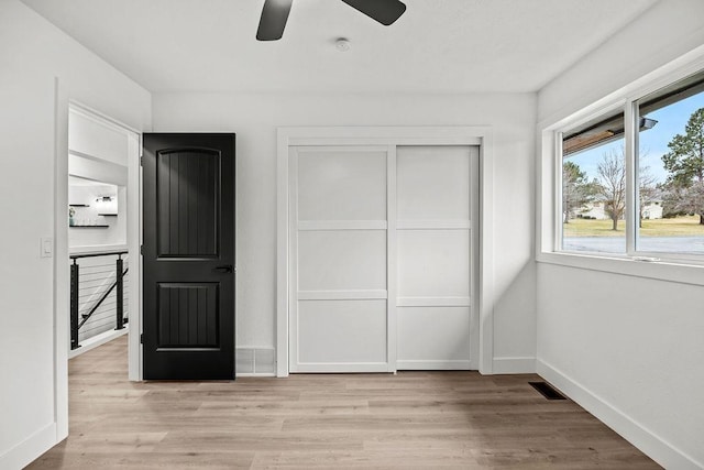 unfurnished bedroom with a ceiling fan, visible vents, baseboards, a closet, and light wood-type flooring