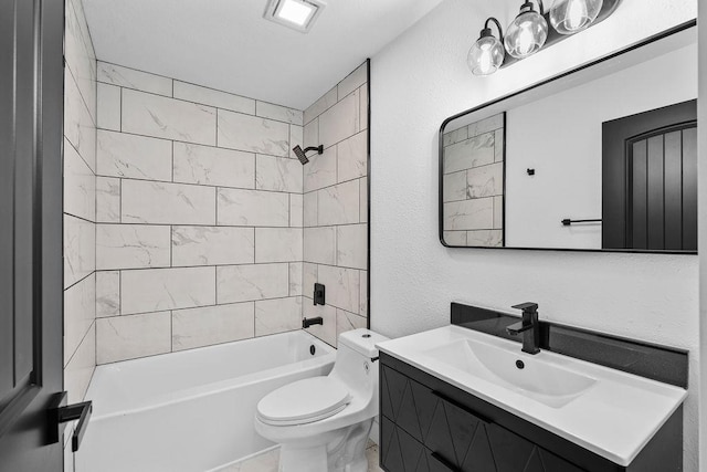 bathroom with a textured wall, bathing tub / shower combination, vanity, and toilet