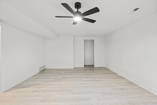 empty room with light wood-style floors, visible vents, baseboards, and a ceiling fan