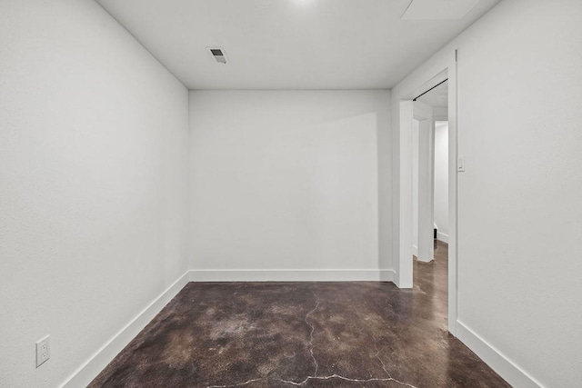 unfurnished room featuring concrete flooring, visible vents, and baseboards