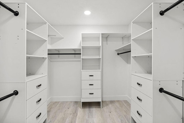 walk in closet with light wood-style flooring