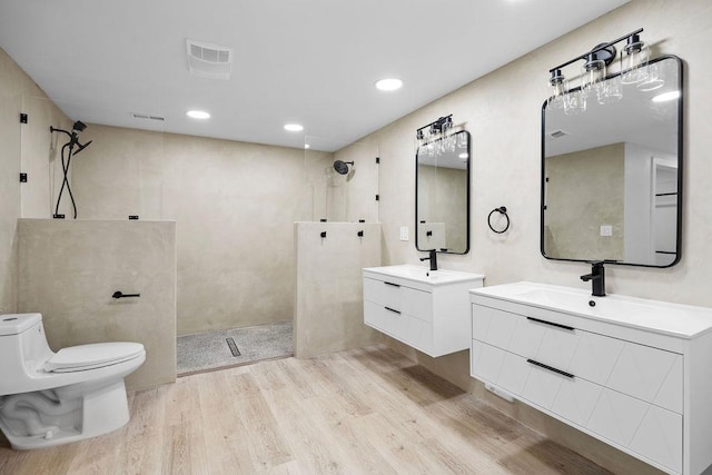 bathroom with visible vents, a walk in shower, a sink, and wood finished floors