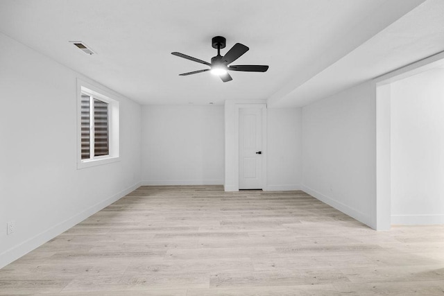 spare room featuring a ceiling fan, visible vents, light wood-style flooring, and baseboards